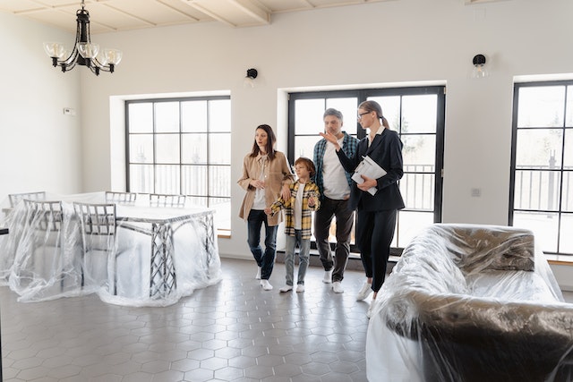 A property manager walking through a rental property with a young couple